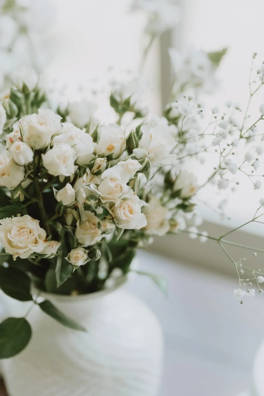 Bouquet di rose bianche e gypsophila in vaso