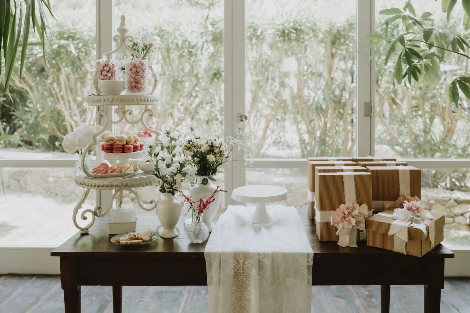 Sweet table elegante con fiori, macarons e confezioni regalo